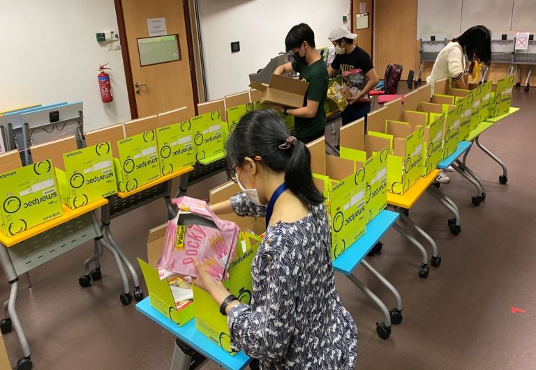 Dr Chng and the NUSPS 60th Exco hard at work to pack over 80 carnival packs