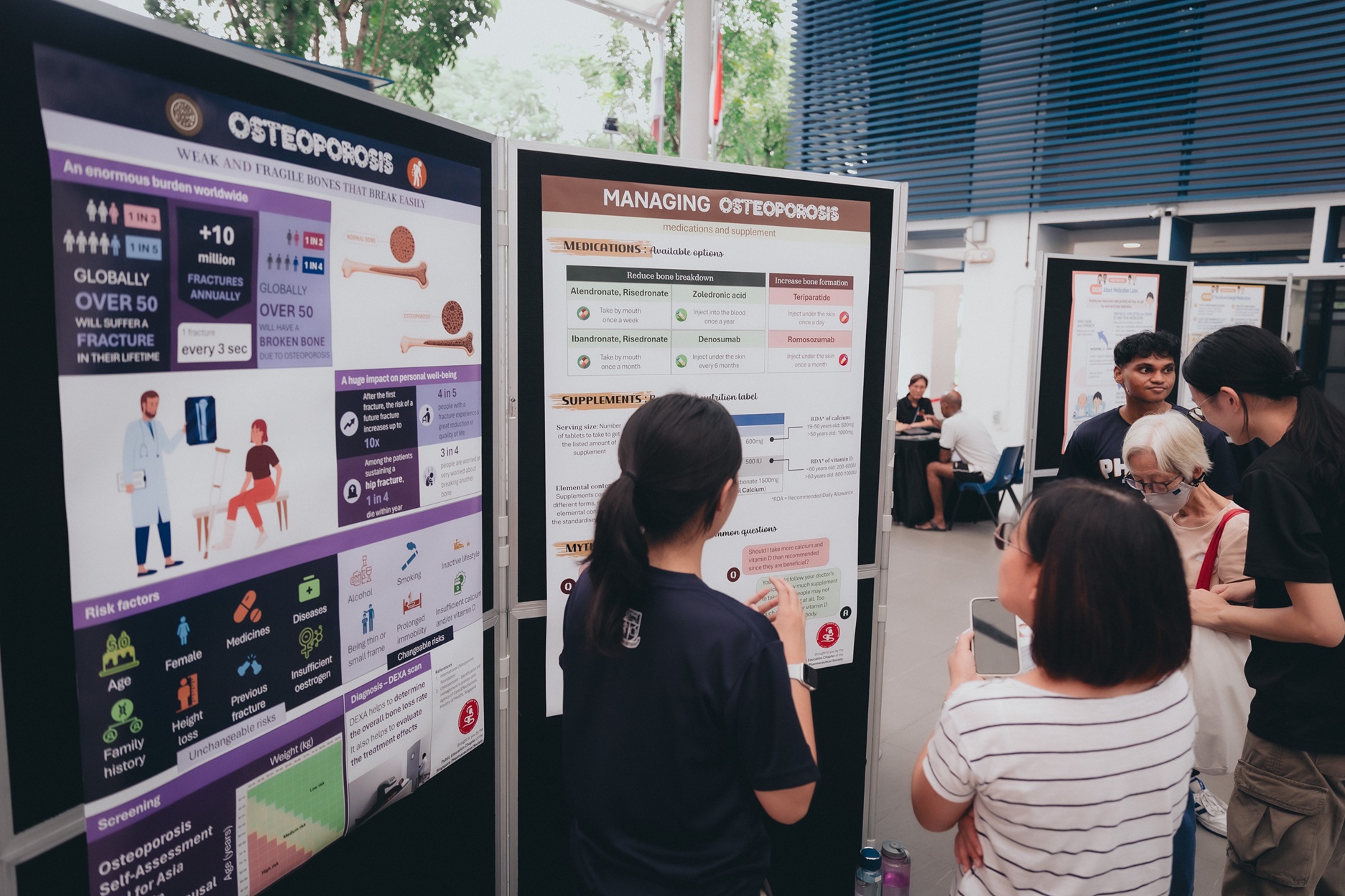 Student volunteers facilitating information sharing on osteoporosis management at poster booths