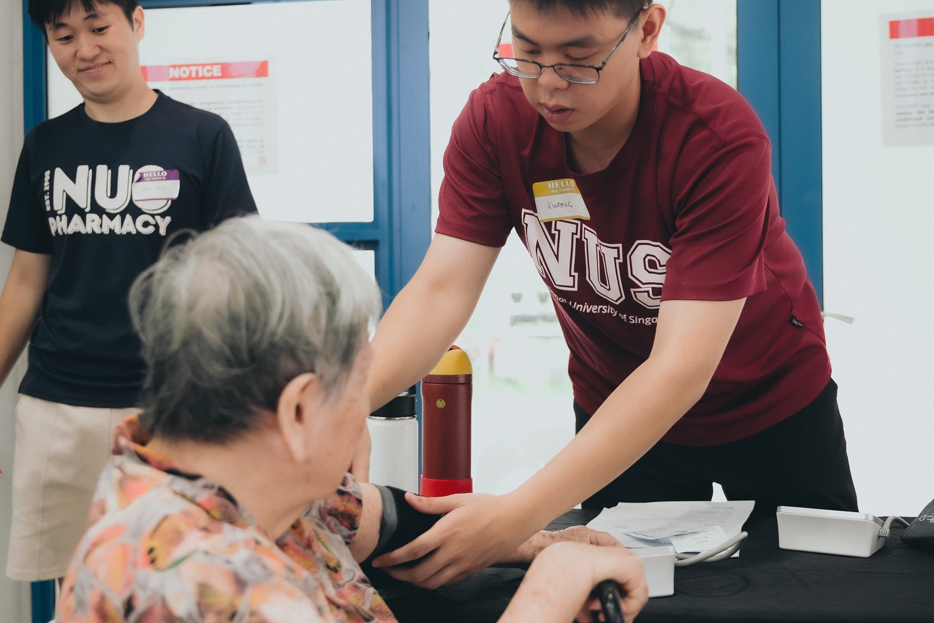 Mr Kwang Shin Kai (Y1 BPharm) measuring blood pressure for a participant, supervised by Mr Goh Jun Hui (Y4 BPharm)