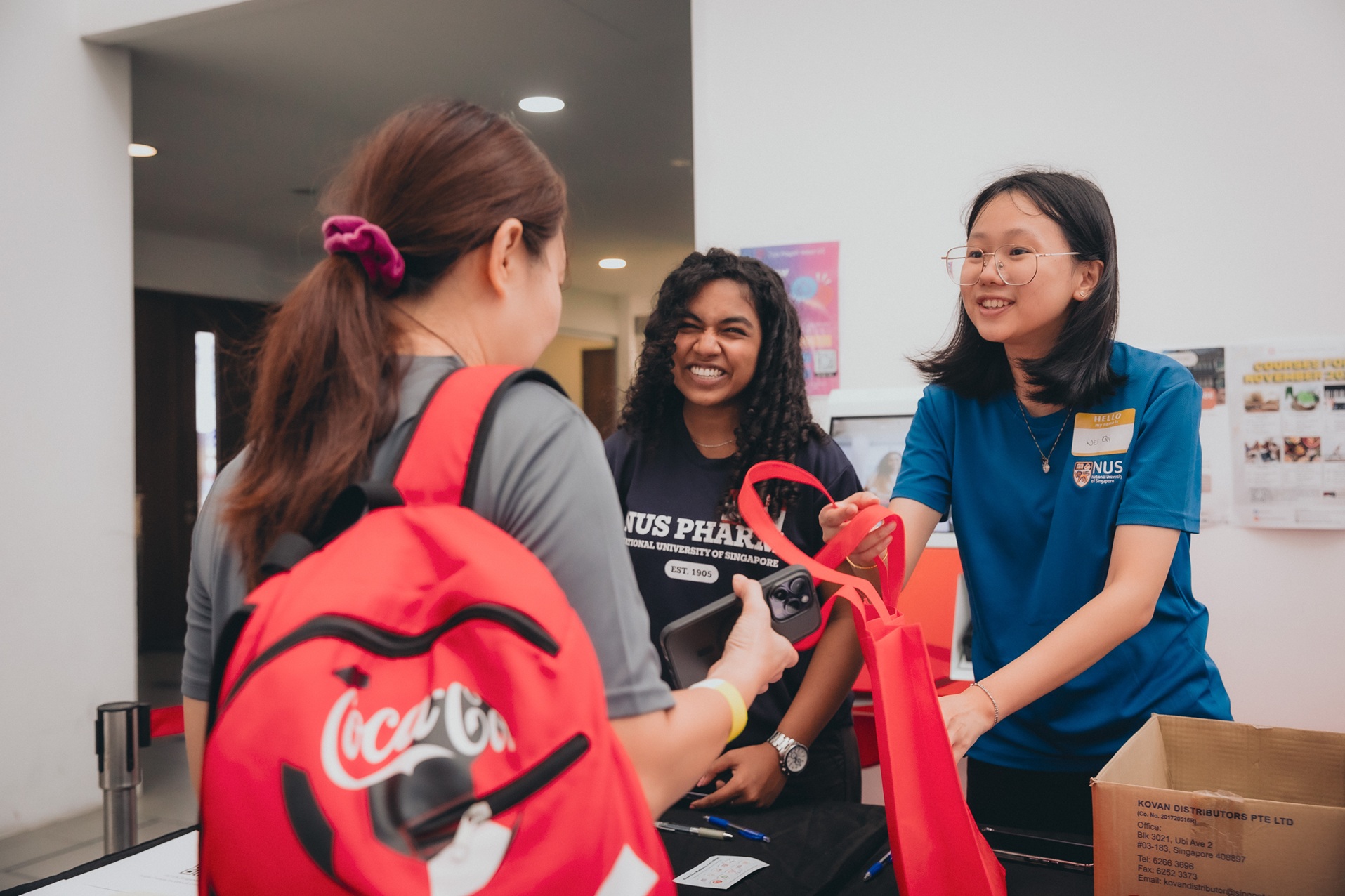 Ms Hannah Kaitlyn Lawrence (Y1 BPharm) and Ms Tee Wei Qi (Y1 BPharm) in action at the registration booth