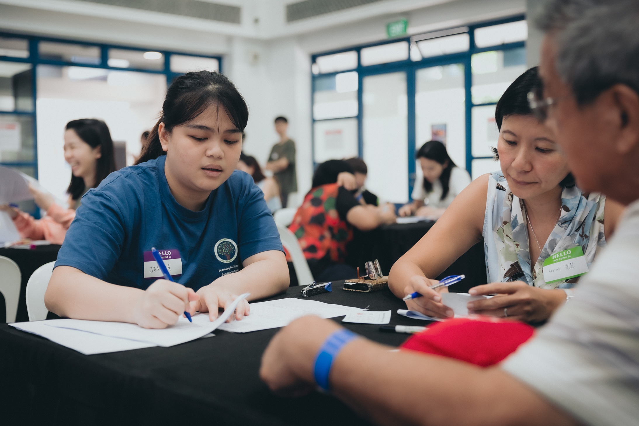 Ms Jessica Ngoh (Y3 BPharm) assisting Ms Adeline Wee (Alumni and pharmacist) at medication review booth with medication history-taking and reconciliation.