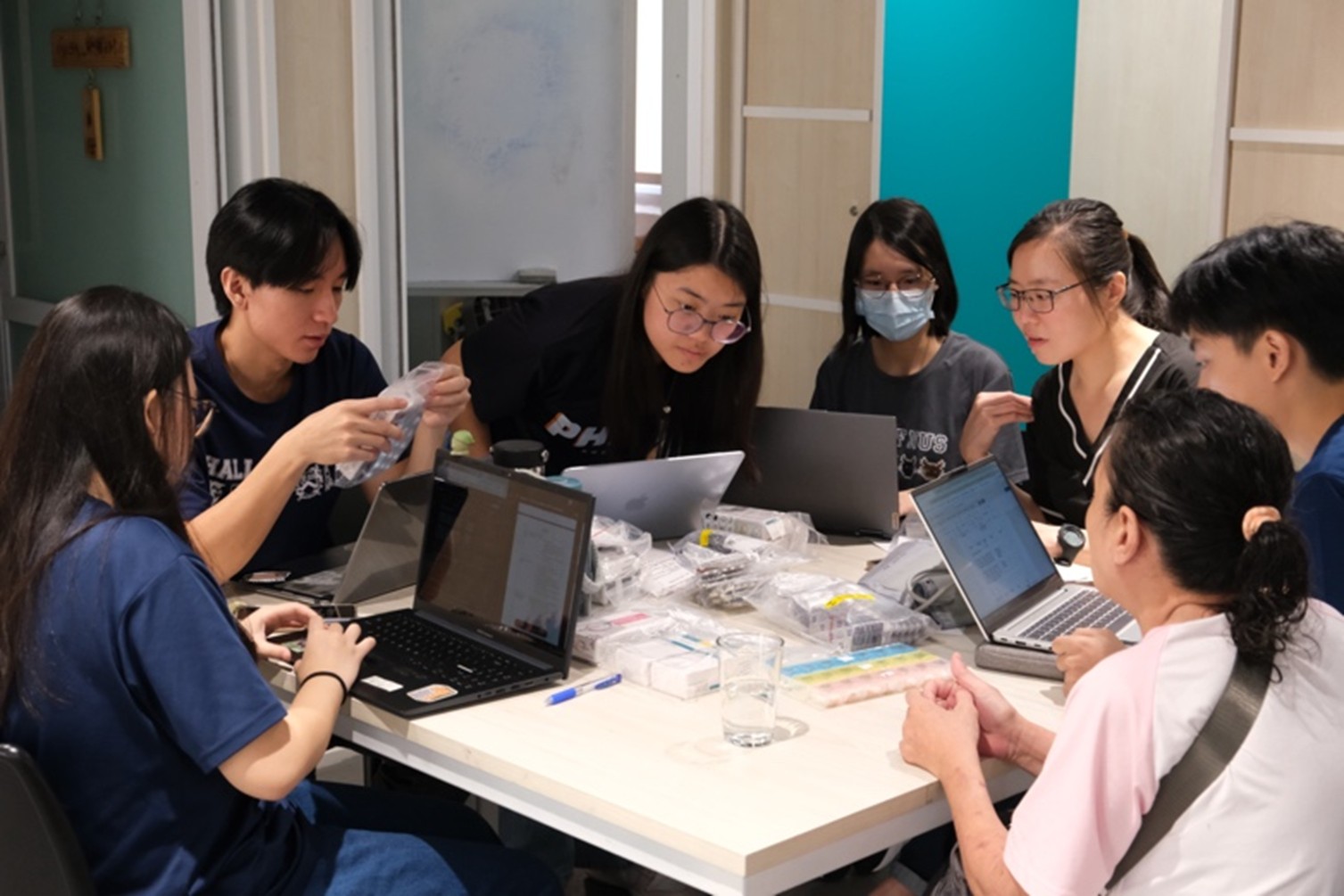 Neo Qian Rui (Y3), Lim Jia De (Y3), Felicity Tan (Y2), Michelle Lim (Y2), and Jordan Leong (Y3) sorting through a client’s medications during medication reconciliation with pharmacist mentor Ms Chan Shi Mun.