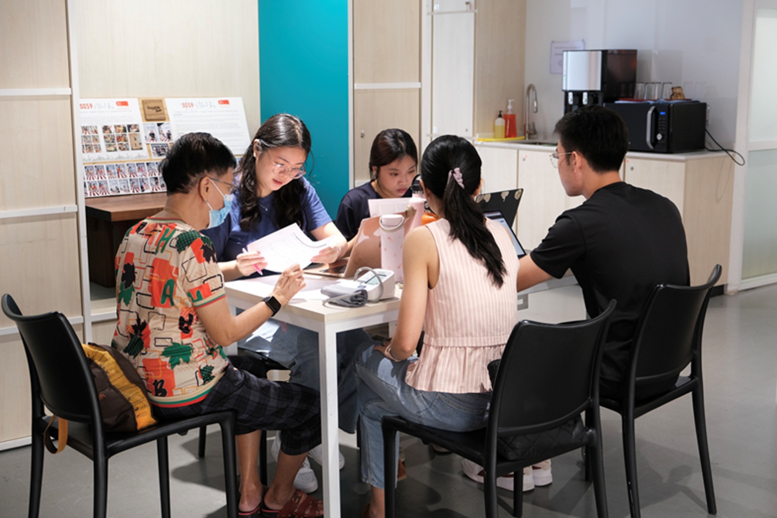 Charlize Ling (Y2), Tan Swee En (Y1) and Theodore Quek (Y3) checking through the reconciled medication list they have prepared for their client, with guidance from pharmacist mentor Ms Meredith Zhuo.
